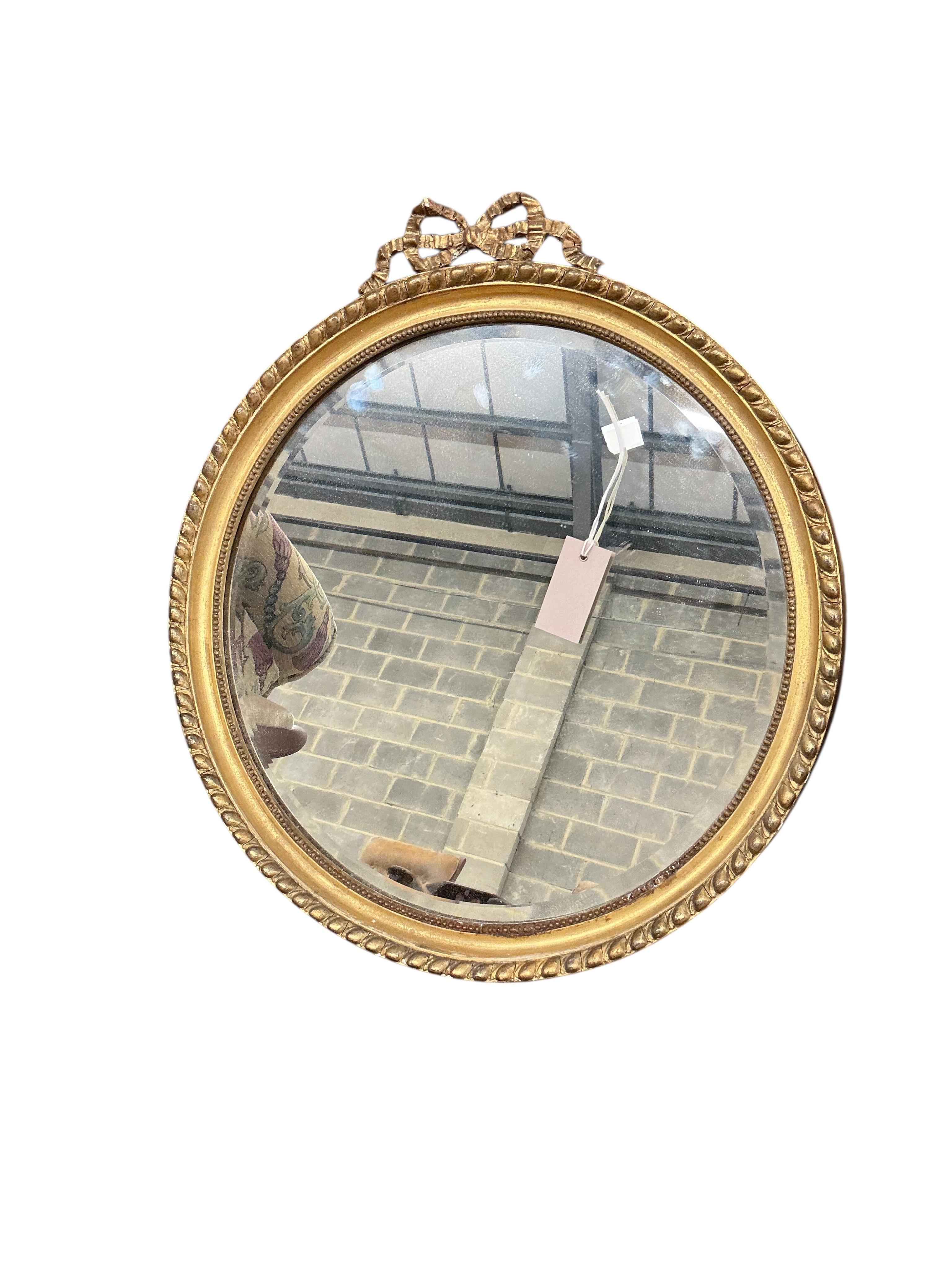An early 20th century French giltwood and composition circular wall mirror, diameter 51cm, together with an Edwardian oval bevelled mirror and a Regency style wall mirror